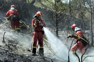 Varios soldados de la UME refrescan el monte calcinado, cerca de Costur