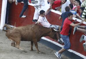 En la imagen , un toro corneando a un joven en la plaza de toros