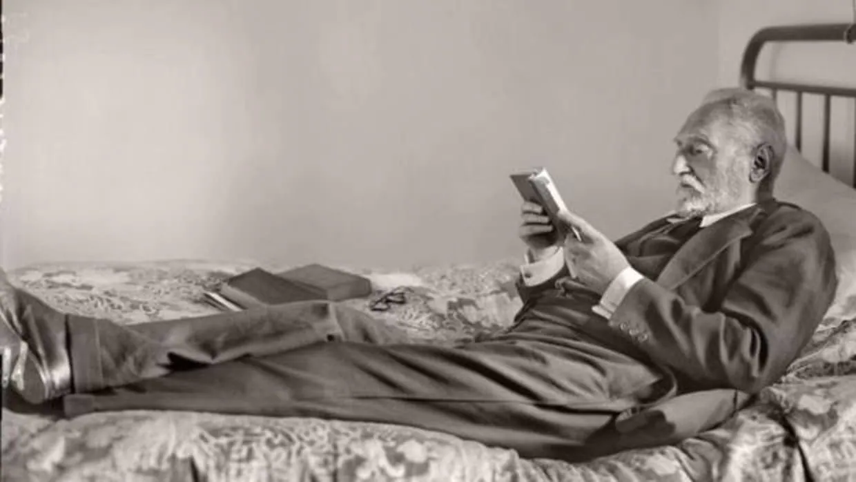 Miguel de Unamuno leyendo tumbado en una cama de su casa