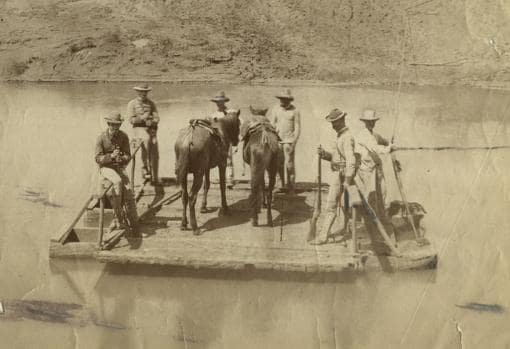 Una pareja de la Guardia Civil conduce a Santiago de Cuba, en enero de 1895, a varios prisioneros. El grupo está atravesando el río Cauto en una balsa de sirga