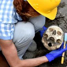 Arqueóloga limpiando un cráneo en Pompeya en agosto de 2018