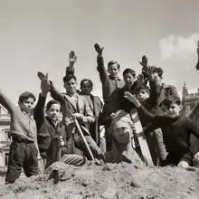 Niños saludando con el brazo en alto durante las obras de desescombro de la Cibeles en 1939