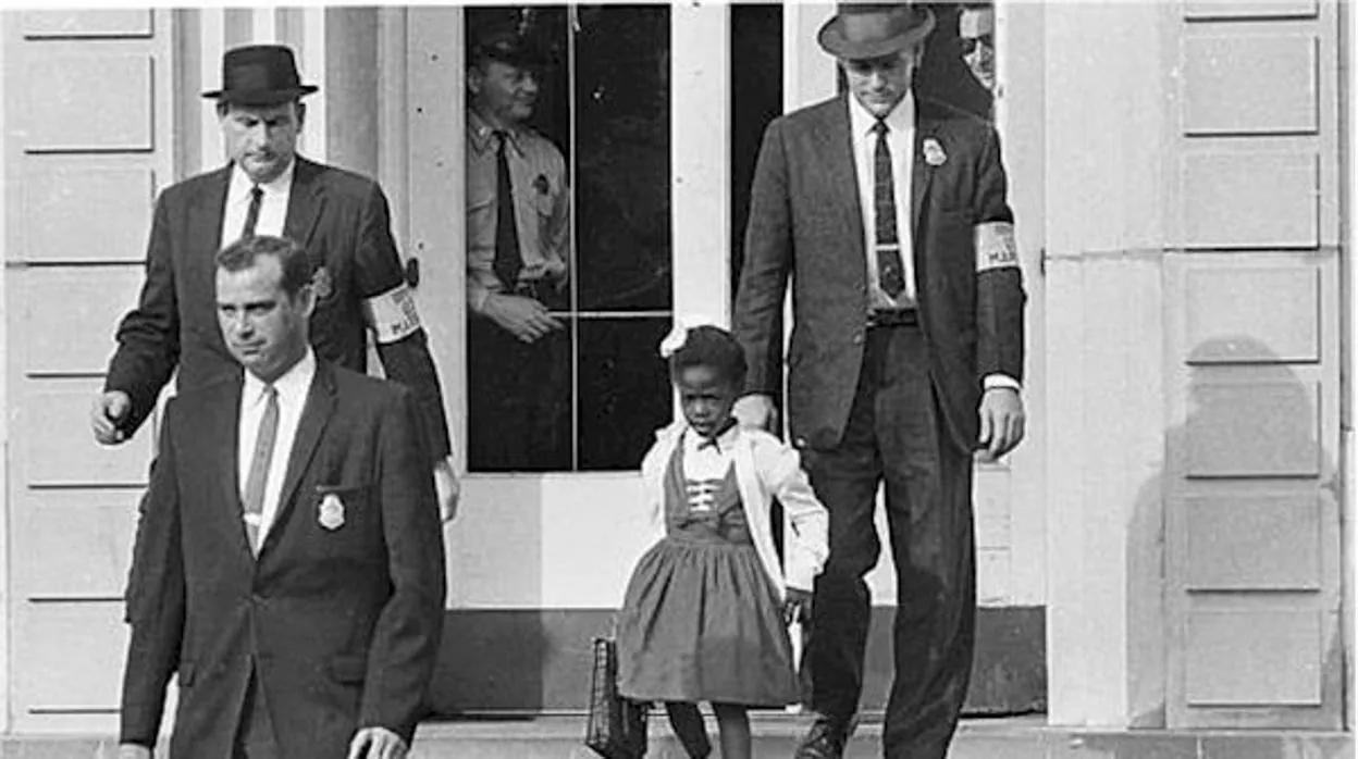Ruby Bridges custodiada por agentes federales a la salida de la escuela en 1960.