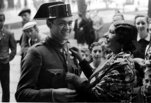 La popular artista Pastora Imperio imponiendo una banderita de la Cruz Roja a un Guardia Civil, durante la fiesta de la banderita.