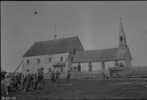 Niños jugando fuera de la Escuela Residencial Indígena Providence Misión, alrededor de 1920.