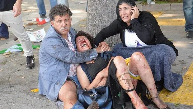 Dos personas ayudan a una mujer herida durante el atentado de Ankara