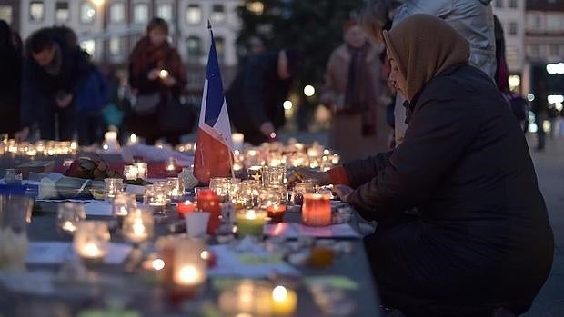 Una mujer deposita una vela en memoria de los fallecidos en la masacre