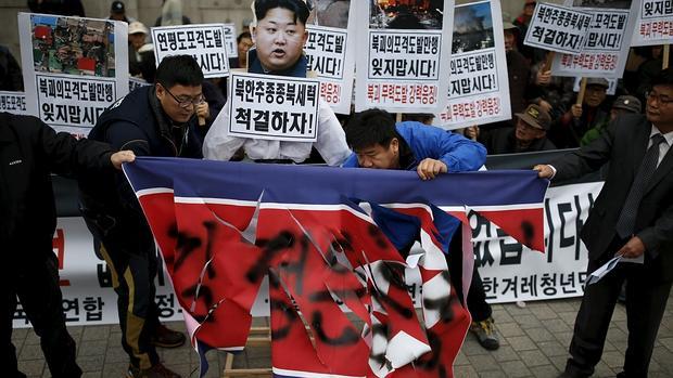 Manifestantes arsgan una bandera de Corea del Norte en una manifestación en Seúl este lunes