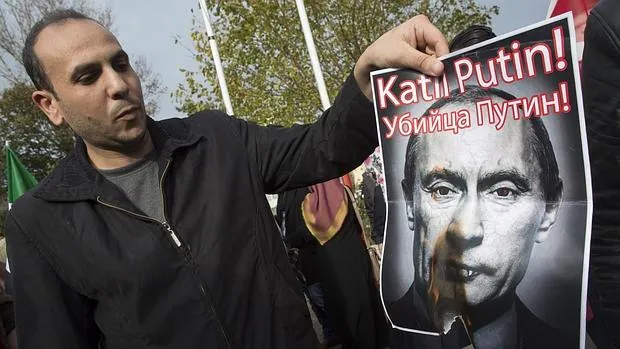 Un manifestante turco quema una pancarta con una fotografía del presidente ruso, Vladímir Putin, durante una protesta en Estambul, Turquía