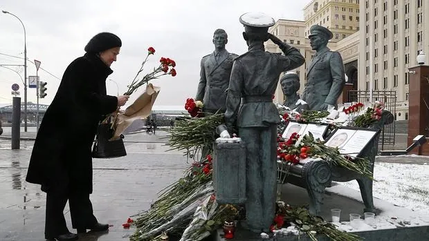 Una mujer coloca flores en memoria del piloto fallecido tras el derribo del cazabombardero ruso Su-24 por Turquía el pasado 24 de noviembre, ante el ministerio de Defensa ruso en Moscú, Rusia