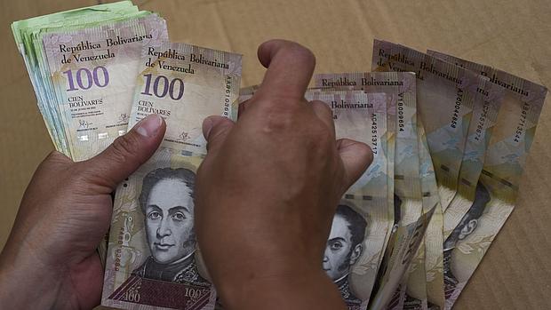 Una mujer cuenta dinero en un mercado de Caracas este viernes