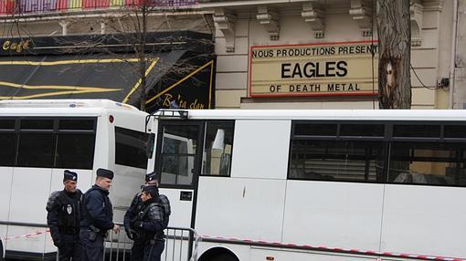 Varios policiías hacen guardia en la sala Bataclan, bajo el cartel de los Eagles