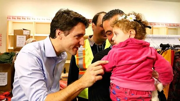 El primer ministro canadiense, saludando a una niña refugiado el pasado jueves en el aeropuerto de Toronto