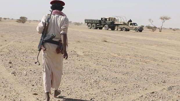 Un miembro de una milicia leal al gobierno depuesto se dirige hacia vehículos hutíes destruidos en una ofensiva