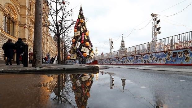 Un árbol de Navidad se refleja en un charco en la Plaza Roja de Moscú