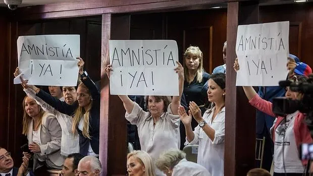 Lilian Tintori (3-i), Mitzi Capriles (c) y Patricia Ceballos (d) muestran carteles pidiendo una ley de amnistía durante la instalación de la Asamblea Nacional