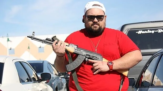Nicholas Páez muestra su AK 47 recién comprado en la Feria de Armas de Miami