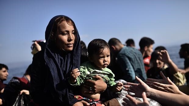 Una mujer y su bebé son atendidos a su llegada a la isla griega de Lesbos
