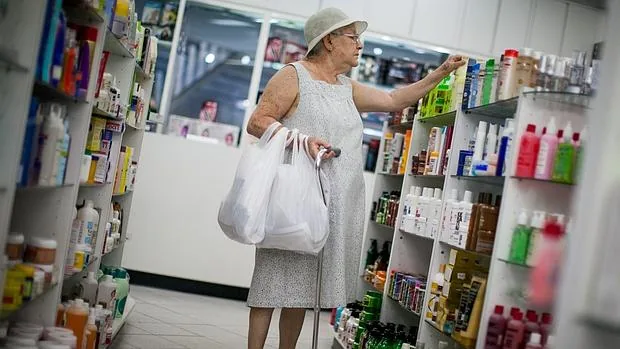 Una mujer busca un producto en una farmacia de Caracas
