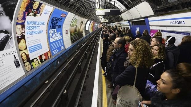 Un grupo de pasajeros espera el metro en la estación londinense de Victoria