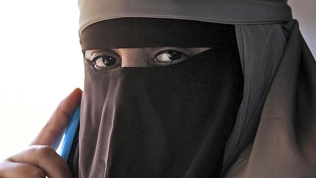Una musulmana con niqab habla por su móvil