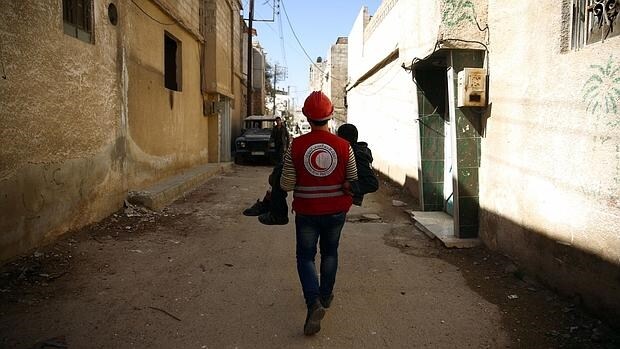 Un voluntario de la Media Luna Roja traslada a un herido en un bombardeo sobre la localidad de Duma, cerca de Damasco