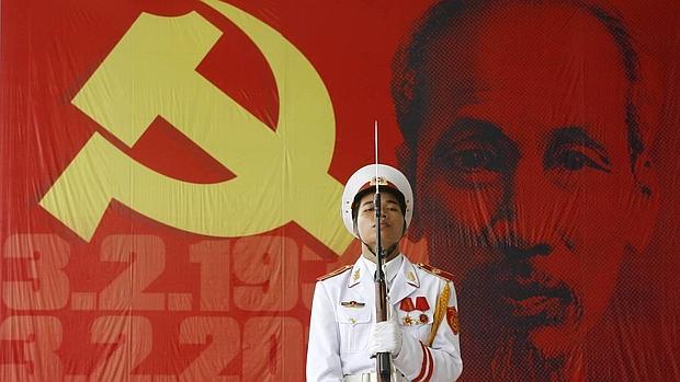 Un militar sostiene un rifle ante una imagen del líder comunista vietnamita Ho Chi Minh