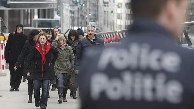 Un grupo de empleados abandona un edificio en Bruselas tras ser evacuado