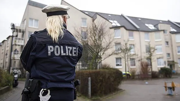 Una policía alemana hace guardia en un bloque de viviendas de Düsseldorf, Alemania