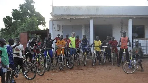 Varios niños con sus nuevas bicis rodean a Boule (en el centro)