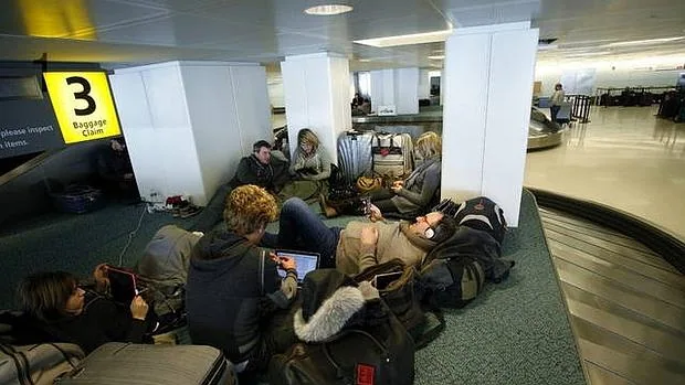 Varios pasajeros acampan mientras esperan para embarcar en un aeropuerto Charles de Gaulle AFP
