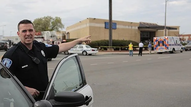 Un agente de Policía señala la estación de autobuses donde se ha producido el tiroteo