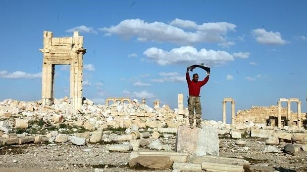 Un soldado sirio junto a los daños causados por Daesh en la histórica ciudad de Palmira (Siria)