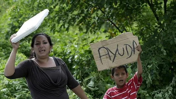 Una mujer y su hijo piden ayuda en Canoa, una de las poblaciones ecuatorianas afectadas por el terremoto