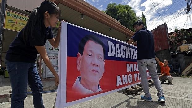 Varios simpatizantes extienden un cartel de apoyo a Duterte