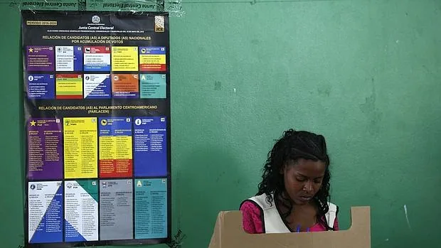 Una mujer deposita su voto este domingo en Santo Domingo