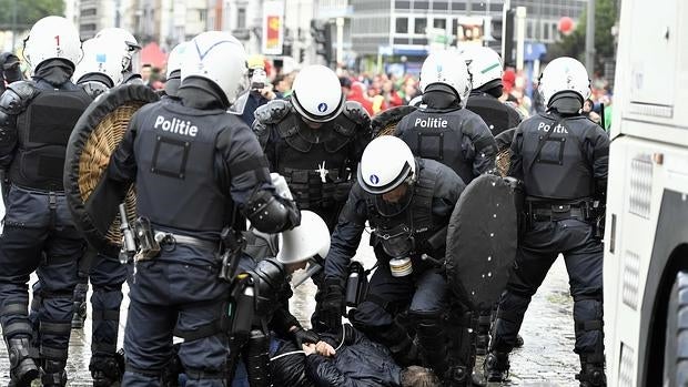 La policía detiene a uno de los manifestantes que participaba en la marcha antiausteridad contra el Gobierno belga y que acabó con disturbios