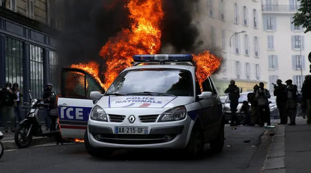 Un coche policial incendiado durante una protesta contra la reforma laboral