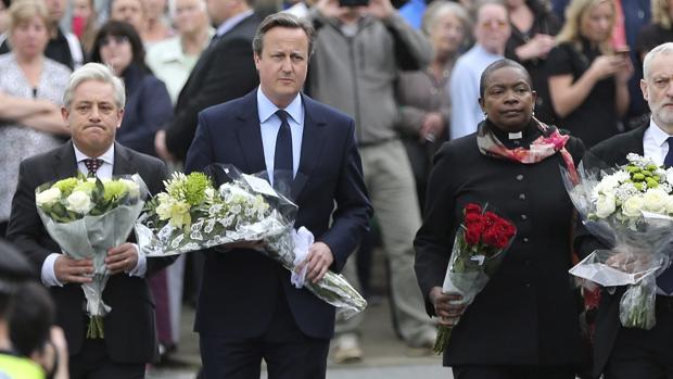 El primer ministro David Cameron (2i), presidente de la Cámara de los Comunes británica, John Bercow (i) y el líder laborista Jeremy Corbyn llevan flores al altar improvisado de Jo Cox