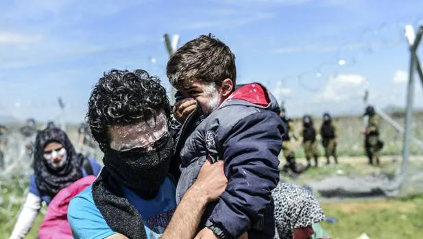 Fotografía de archivo de una familia siria fotografiada en abril, en el campo de Idomeni (Grecia). Están protegidos con pasta de dientes como protección contra gases lacrimógenos