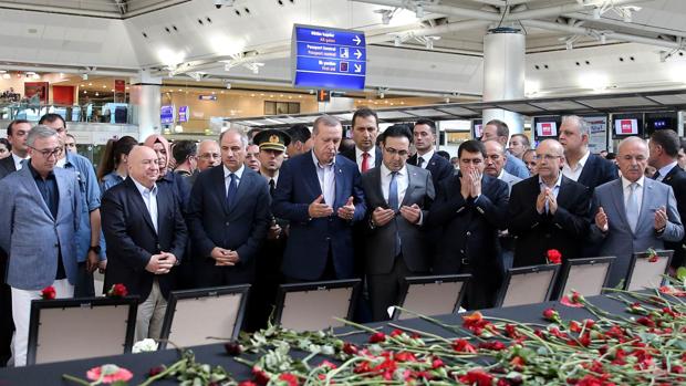 RErdogan (centro) reza en el aeropuerto de Ataturk en Estambul en memoria de las víctimas del ataque terrorista el pasado 2 de julio