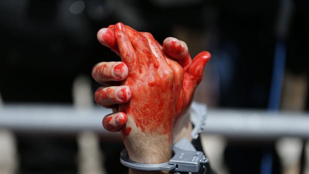 Un manifestante se mancha las manos de sangre para criticar la decisión de Tony Blair de invadir Irak en 2003
