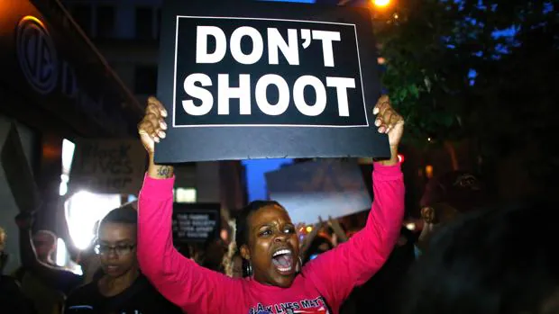 Una manifestante del grupo Black Lives Matter levanta una pancarta que lee «No disparéis» en una concentración en Nueva York el 9 de julio
