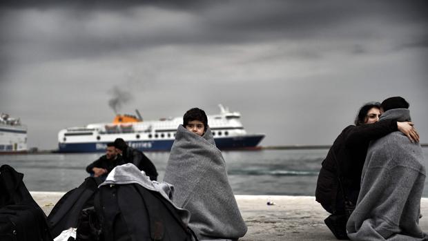 Varios niños se cubren con mantas en el puerto de Lesbos