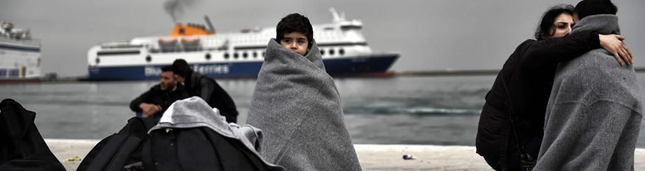 Varios niños se cubren con mantas en el puerto de Lesbos