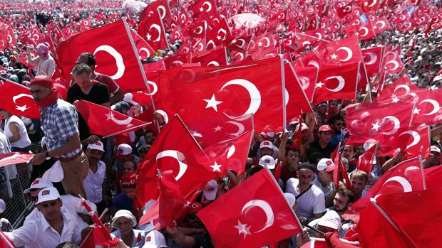 Varios asistentes a la multitudinaria manifestación se agolpan para escuchar al presidente Erdogan hoy en Estambul