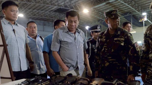 Duterte examina ayer, 9 de agosto, varias de las armas confiscadas por la policía militar