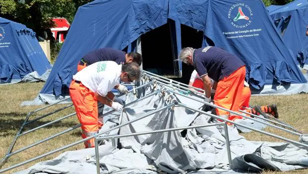 Voluntarios montan carpas en el campamento temporal que se ha improvisado en la localidad italiana de Amatrice tras el terremoto