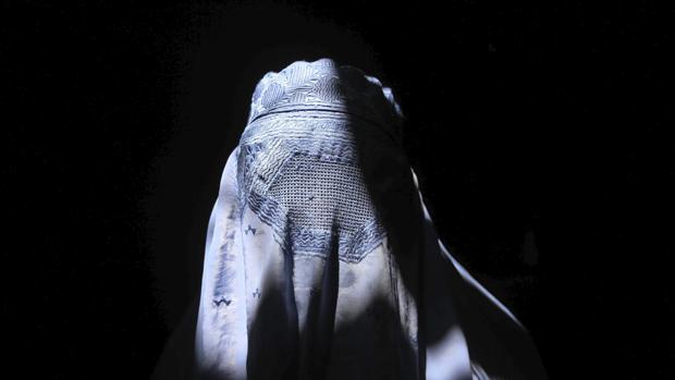 Una mujer afgana vestida con un burka camina por una calle en Herat, Afganistán