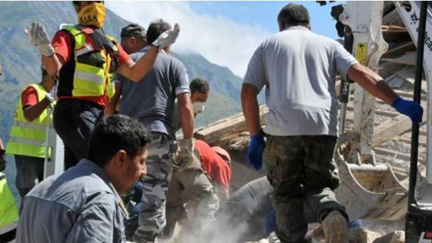 Un grupo de efugiados ayuda a retirar esconbros tras el terremoto que ha asolado el centro de Italia